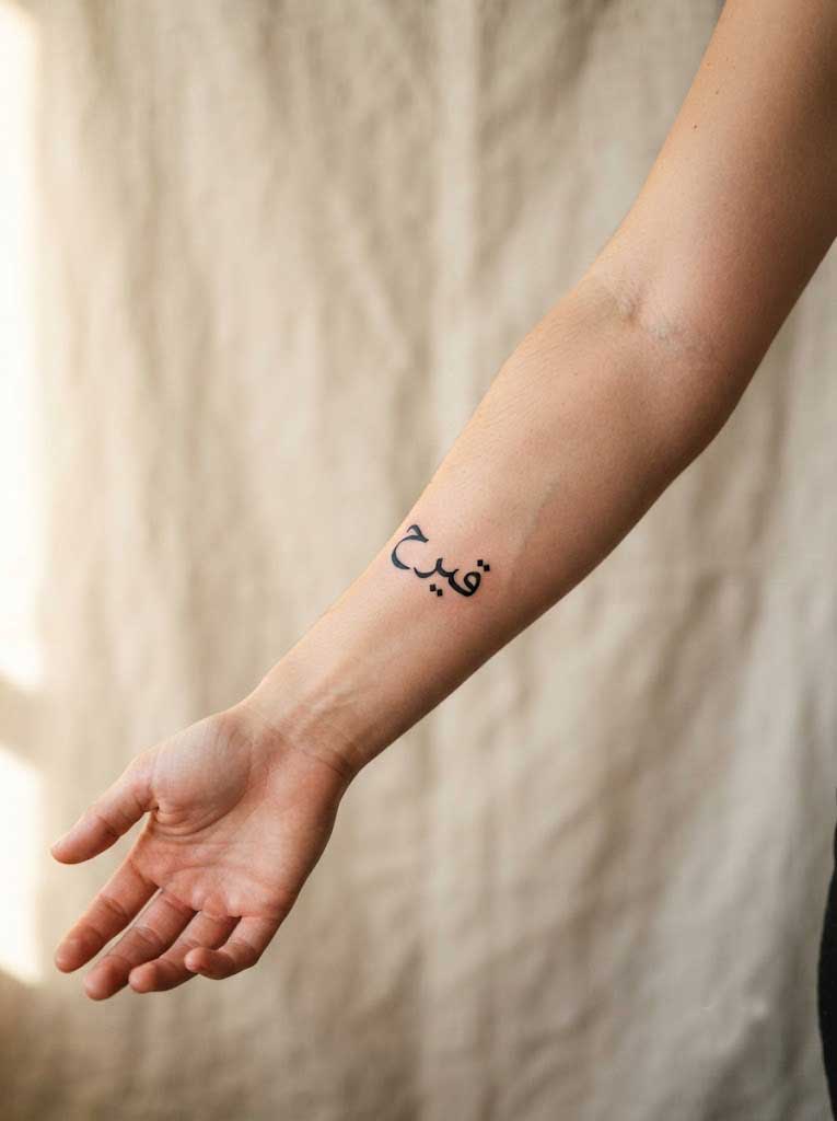Hurriya (freedom) Arabic tattoo in Naskh calligraphy on forearm